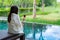 Woman clothed bathrobe sitting on deckchair in pool