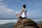 Woman clothing in white meditation at the seaside cliff edge