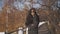 Woman in coat and sunglasses in autumn park. Student girl walking in glasses and posing.