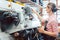 Woman cobbler working on machine in her shoemaker workshop