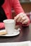 Woman with coffee reading newspaper