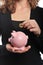 Woman with coin and piggy bank