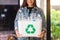 A woman collecting and holding a recyclable garbage plastic bottles in a trash bin