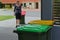 Woman collecting rubbish bin from road side