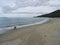 A woman collecting shels on almost empty beach.