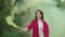 Woman with color smoke bomb walking through forest