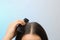 Woman with comb and dandruff in her dark hair