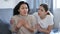 Woman comforting her friend after a domestic quarrel while sitting on the couch