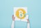 Woman completing a puzzle with a bitcoin icon