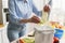 Woman composting food leftovers at home. Female recycling organic waste in a bokashi bin. Person put cabbage leaves in a compost