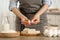 Woman with compressed yeast at wooden table indoors, closeup