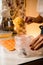 Woman confectioner fills confectionery bag with freshly prepared cream, closeup view. Blurred background