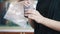 Woman confectioner hands makes swirls on muffin with creme on plate upon table