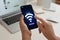 Woman connecting to WiFi using mobile phone at table, closeup