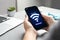 Woman connecting to WiFi using mobile phone at table, closeup