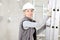 Woman construction worker builder wearing white helmet holding a ladder on  interior site building background with scaffolding