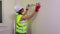 Woman construction worker with spirit level near wall