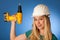Woman with constructor helmet and electric wrench happy to do to