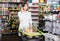 Woman consulting on phone about shopping in supermarket