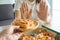 Woman controls the food, using her hands to push the pizza dish