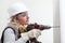 Woman contruction worker using cordless drill driver making a hole in wall, builder with safety hard hat, hearing protection