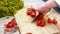 Woman cook chops fresh tomatoes