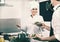 Woman cook giving to waitress ready to serve salad