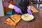 woman cook with gloves mashing boiled potatoes to prepare salad