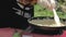 Woman cook stirring dish into the frying pan