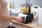 Woman cook turning on button of food processor for kneading dough closeup