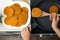 Woman cooking breaded cutlets in frying pan on stove, top view