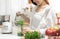 Woman cooking Broccoli smoothie with a blender