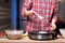 Woman cooking delicious crepe on electric pancake maker in kitchen, closeup