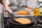 Woman cooking delicious thin pancakes on induction stove