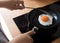 Woman cooking egg fried on black pan in morning.Food concepts