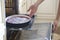 Woman cooking in the kitchen, puts cakes in the oven. preparation of a French pie with cherries. Clafoutis cherry pie.