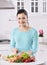 Woman cooking in new kitchen making healthy food with vegetables.