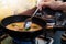 Woman cooking pork noodle soup at kitchen gas stove