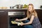 Woman cooking saltwater fish in oven at kitchen