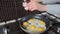 Woman cooking the scrambled eggs on frying pan