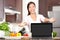 Woman cooking showing laptop in kitchen