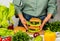 Woman is cooking tasty burger with cutlet, chesse and vegetables in the kitchen.