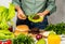 Woman is cooking tasty burger with cutlet, chesse and vegetables in the kitchen.