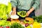 Woman is cooking tasty burger with cutlet, chesse and vegetables in the kitchen.