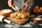 Woman cooking tasty pasta on dark table