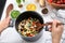 Woman cooking tasty rice with vegetables in saucepan