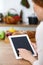 Woman cooks at the kitchen using tablet computer. Copy space area at touch pad. Healthy meal, vegetarian food and