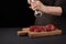 A woman cooks with peppers fresh raw steak from marbled beef on a dark background. Food background. Black text area. Copy space