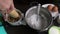 Woman cops walnut. Cooking a cake of biscuit crumbs and milk jelly. On the surface of the table are the ingredients and cooking ut