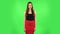 Woman coquettishly smiling while looking at camera. Green screen